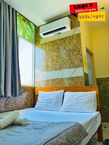 Un dormitorio con una cama con sábanas blancas y una ventana. en Khách sạn Thế Giới Mới - Thế Giới Mới Hotel, en Ho Chi Minh