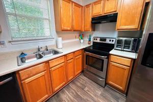 une cuisine avec des armoires en bois, un évier et une cuisinière dans l'établissement 856 Joseph Club Dr SW Mableton, à Mableton 1 autre photo