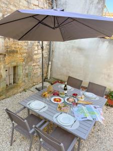 a picnic table with plates of food and an umbrella at L'Ecrin de Chablis in Chablis +21 photos