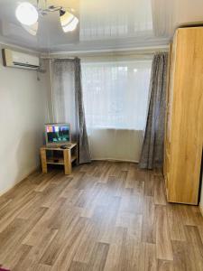 a living room with a television and a wooden floor at ApartCenter апартаменты в центре Gagarin mall in Kryvyi Rih