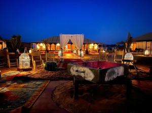 a room with a tub and chairs and a building at Merzouga Aicha Luxury Camp in Merzouga
