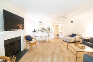 a living room with a television and a living room with a fireplace at Seagrove Villa 5B - Oceanside Villa in the Trees in Isle of Palms