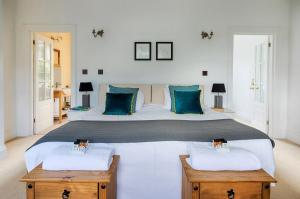 a bedroom with a large bed with blue pillows at Lambourn House, Countryside Retreat for up to 26 in Lambourn