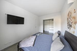 a bedroom with a bed and a flat screen tv at San Carlo Borromeo in Soiano del Lago