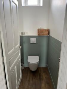 Brassac-les-MinesMaison 8 personnes的浴室设有白色卫生间和绿色墙壁。 更多2张照片