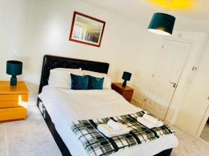 a bedroom with a bed with two towels on it at Cozy Stays Taunton in Norton Fitzwarren