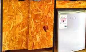 a white refrigerator next to a wooden wall at Yet Shipping Container in Christiansborg