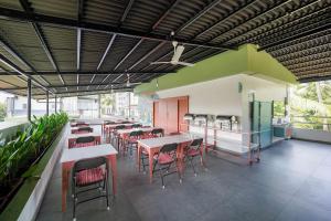 a cafeteria with tables and chairs in a building at Sreenivas Lodge by Copperfolia in Kozhikode