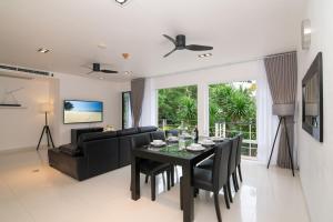 カマラビーチにある3-BR Condo Mountain & Pool view, Pool & Gym access - Kamala Hills G201のダイニングルーム、リビングルーム(黒いテーブル、椅子付)