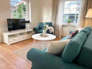 a living room with a blue couch and a tv at Muscheleck FeWo 2 in Döse