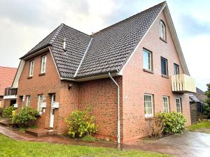 a red brick house with a black roof at Muscheleck FeWo 2 in Döse