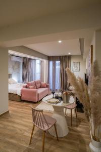 a living room with a bed and a pink couch at Love room & Spa in Larisa