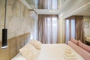 a bedroom with a large white bed with pink accents at Love room & Spa in Larisa