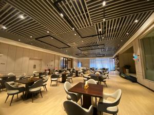 a restaurant with tables and chairs in a room at LIZ International Hotel Guangzhou East Railway Station Zhujiang New Town Branch - Free Shuttle Bus to Canton Fair Complex During Canton Fair Period & Free Deliver Service to Guangzhou Baiyun International Airport & Free VPN Internet Access in Guangzhou