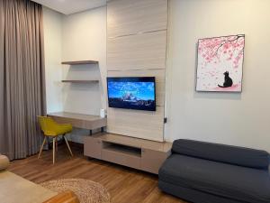 バンドンにあるThe Sakura House - Casa 99 Bandungのリビングルーム(テレビ、黄色い椅子付)