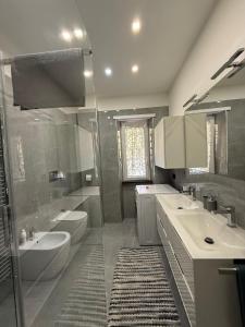 Un baño con dos lavabos, un inodoro y una ducha. en Due Leoni Luxury House, en Roma