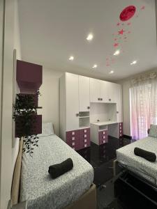 Una habitación con dos camas y una cocina con decoraciones rojas. en Due Leoni Luxury House, en Roma