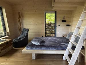 a bedroom with a bed in a wooden cabin at Rokle Tiny house Plandry 