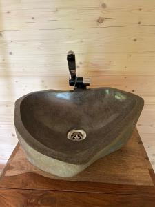 a stone sink on a wooden counter in a bathroom at Rokle Tiny house Plandry 