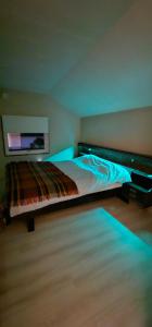 a bedroom with a bed with blue lights on it at Tønsvik Panorama in Tromsø