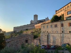 an old building with cars parked in front of it at Delizioso Appartamento Francesco House Family in Assisi