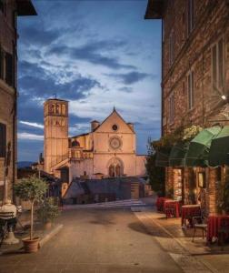 a large building with a clock tower in a city at Delizioso Appartamento Francesco House Family in Assisi