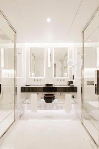 a white bathroom with a sink and mirrors at Lisbon Chiado Hotel & Spa in Lisbon