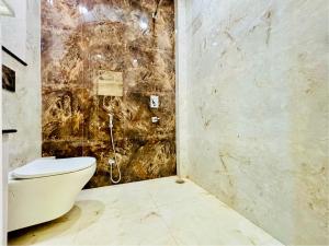a bathroom with a toilet and a stone wall at 3 Raahi Varanasi in Varanasi +10 photos