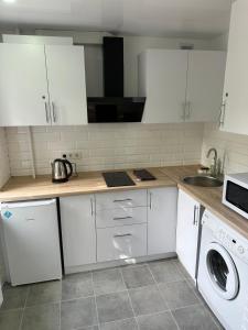 una cucina con mobili bianchi e un lavandino di ApartCenter Студия VIP в центре Гагарина a Kryvyj Rih