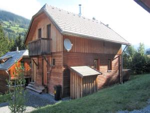 a large wooden building with a porch on a hill at Chalet in St Georgen ob Murau nahe Skigebiet in Sankt Georgen ob Murau