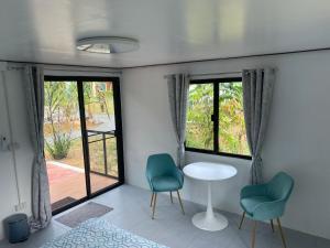 a room with two chairs and a table and windows at Noi’s Paradise Homestay in Phatthalung