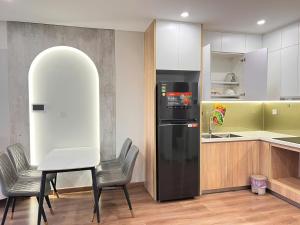 a kitchen with a black refrigerator and a table and chairs at Smart-i11611 in Phú Thú