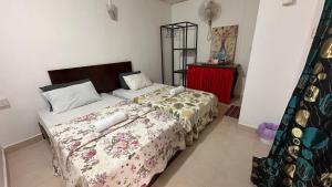 une chambre avec deux lits et une table rouge dans l'établissement Paradise Langkawi, à Pulau Tepur