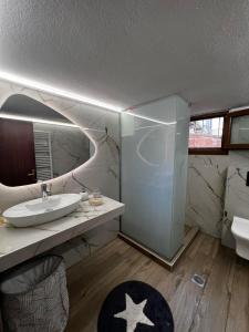 ein Badezimmer mit Waschbecken, Toilette und Spiegel in der Unterkunft IRIDA in Kavala