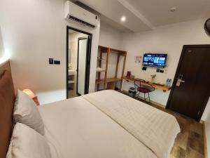 a bedroom with a white bed and a tv at Thành Nam Hotel in Dien Bien Phu