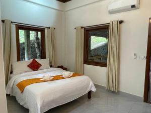 a bedroom with a bed with two towels on it at Villa Kep Sea & Mountains in Phumĭ Ŏng Char