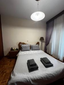 ein Schlafzimmer mit einem Bett, auf dem zwei Handtücher liegen in der Unterkunft IRIDA in Kavala