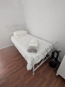 - un lit blanc dans une chambre dotée de parquet dans l'établissement The Cottage on George Street, à Jarrahdale