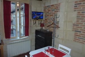 オンフルールにあるStudio des Lingotsのレンガの壁にテレビとテーブル付きのダイニングルーム