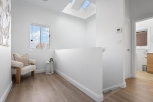 sala de estar blanca con silla y ventana en Sweet Seymour - 3 Bed 2 Bath Cosy & Modern Home, en Bathurst