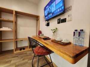 a room with a desk with a television on a wall at Thành Nam Hotel in Dien Bien Phu