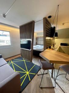 a living room with a couch and a table and a bed at Felix Hotel Darmstadt in Darmstadt