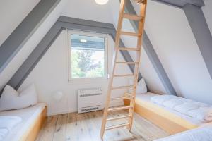 a room with two bunk beds and a ladder at Ferienwohnpark Immenstaad am Bodensee Nurdachhaus Typ 8 NDT 028 in Immenstaad am Bodensee