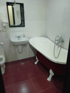 a bathroom with a tub and a sink and a toilet at квартира на Ангиса in Itʼkhvisi