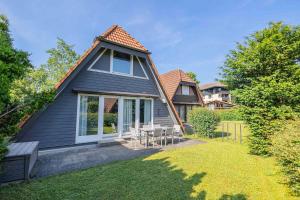 a house with a table and chairs in the yard at Ferienwohnpark Immenstaad am Bodensee Nurdachhaus Typ 8 NDT 028 in Immenstaad am Bodensee
