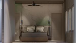a bedroom with a bed with a ceiling fan at M Suites And Hotel in Cochin