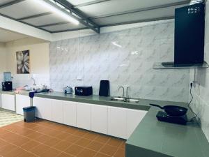 una cucina con bancone, lavandino e piano di lavoro di Newly Refurbished Spacious Home, Family-Friendly, COMFY HILL 2 a Malacca