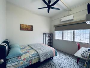 una camera da letto con un letto e un ventilatore a soffitto di Newly Refurbished Spacious Home, Family-Friendly, COMFY HILL 2 a Malacca