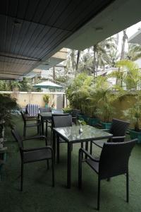 a patio with tables and chairs and plants at Trevon Hotels & Resorts Goa in Goa Velha