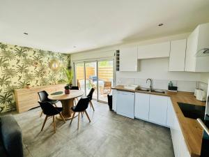 a kitchen with a table and chairs and a sink at La Kaz Eden * * * * in Les Cocos
